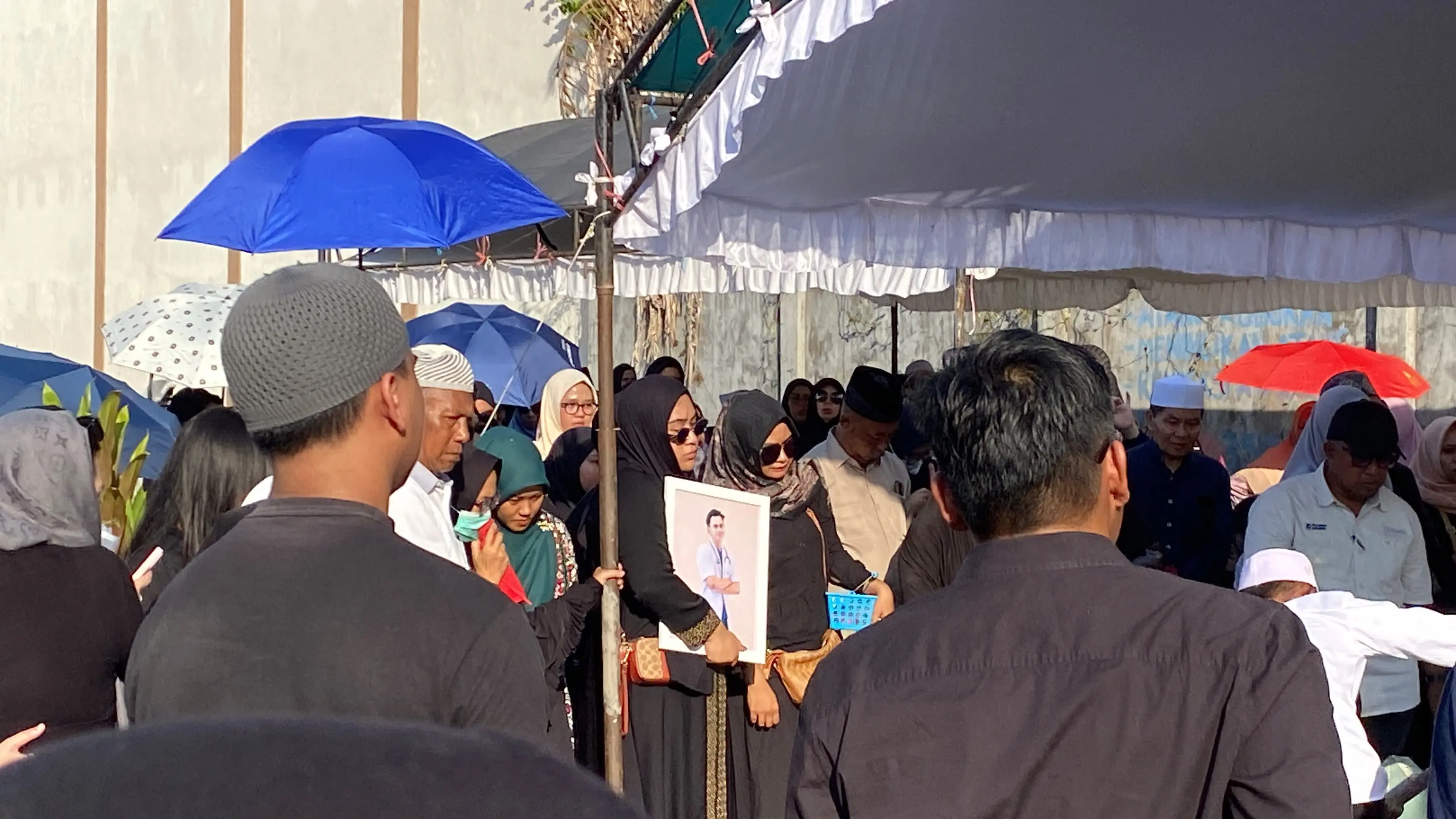 Kakak Muhammad Zulfikar Drakel terlihat memeluk foto almarhum.(Miftah/kaltengpos.jawapos.com)