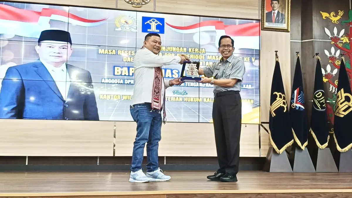 Kakanwil Kemenkum Kalteng, Hajrianor (kanan), saat menyerahkan Plakat kepada Anggota DPR RI Dapil Kalteng , Bias Layar usai kegiatan berlangsung.(Iyan/Kalteng Pos)