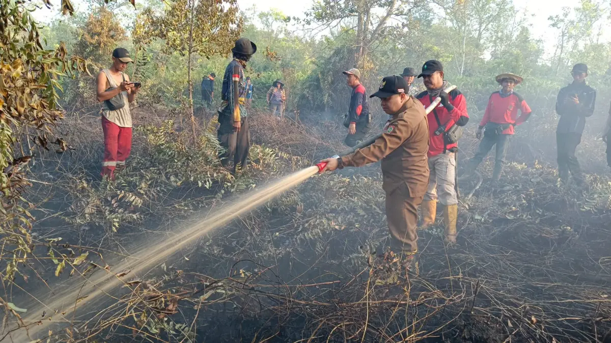 Kepala Dinas Kehutanan Provinsi Kalimantan Tengah Agustan Saining turun langsung memadamkan api.(Humas)