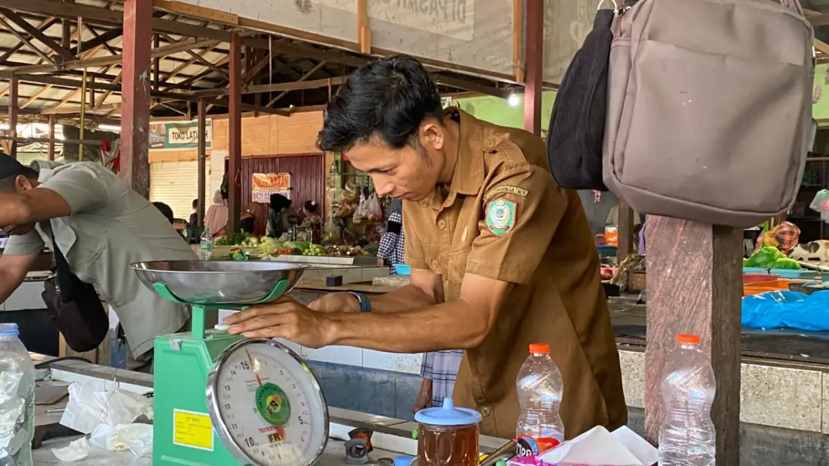 Petugas memeriksa timbangan pedagang.(Miftah/kaltengpos.jawapos.com)