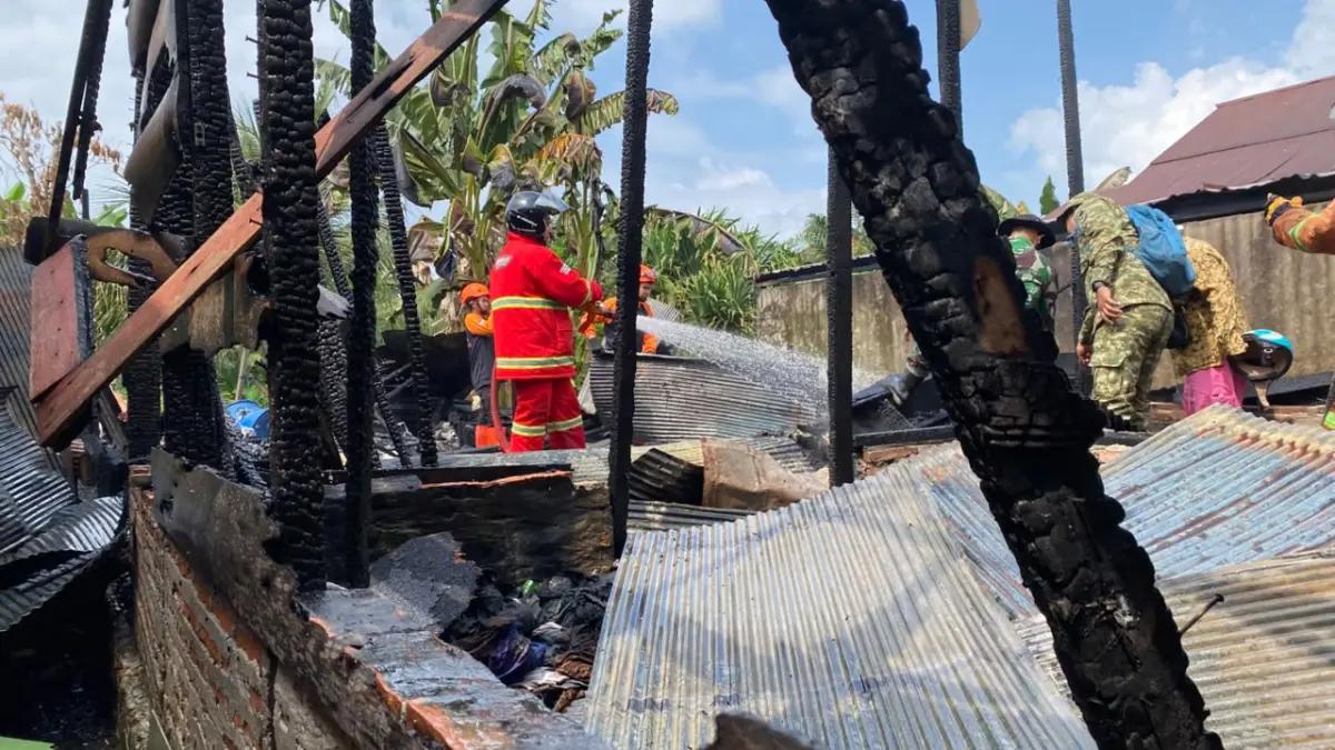 Petugas pemadam melakukan pembahasan rumah yang terbakar.(Miftah/kaltengpos.jawapos.com)