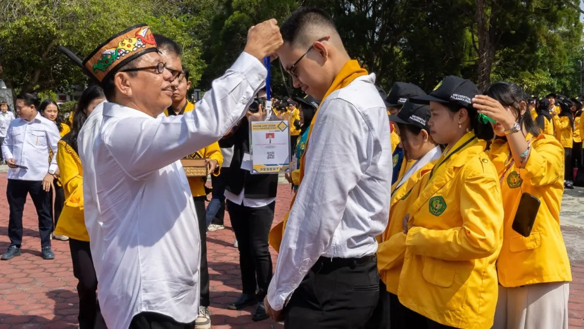 Rektor Universitas Palangka Raya, Prof. Dr. Ir. Salampak, M.S., IPU pasangkan tanda peserta kepada mahasiswa baru, Senin (20/8/2026)