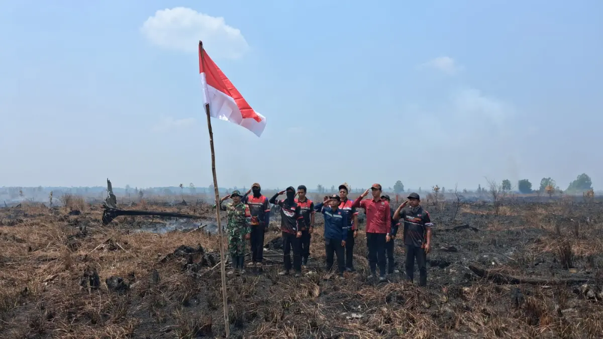 Pengibaran bendera merah putih dan lagu Indonesia Raya di lokasi karhutla Petuk Katimpun Palangka Raya.(Agus Pramono/kaltengpos.jawapos.com)
