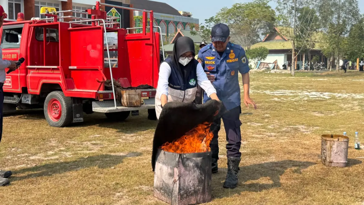 Salah satu mahasiswa UIN Palangka Raya melaksanakan pelatihan pemadaman kebakaran di dampingi oleh petugas kebarkaran. FOTO UIN PALANGKA RAYA