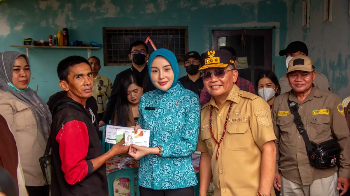 Gubernur Kalteng H Agustiar Sabran bersama istri menyerahkan KHBS kepada warga di Palangka Raya.(Arief Prathama/Kalteng Pos)