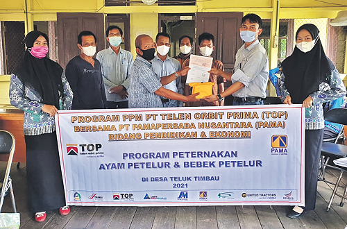 PENYERAHAN BANTUAN : Dindin Suryadin, CSR Section Head PT TOP menyerahkan bantuan kepada Yayasan Pendidikan Mamba’ul Ulum Desa Teluk Timbau untuk program pengembangan ayam petelur, Kamis (29/4/2021).