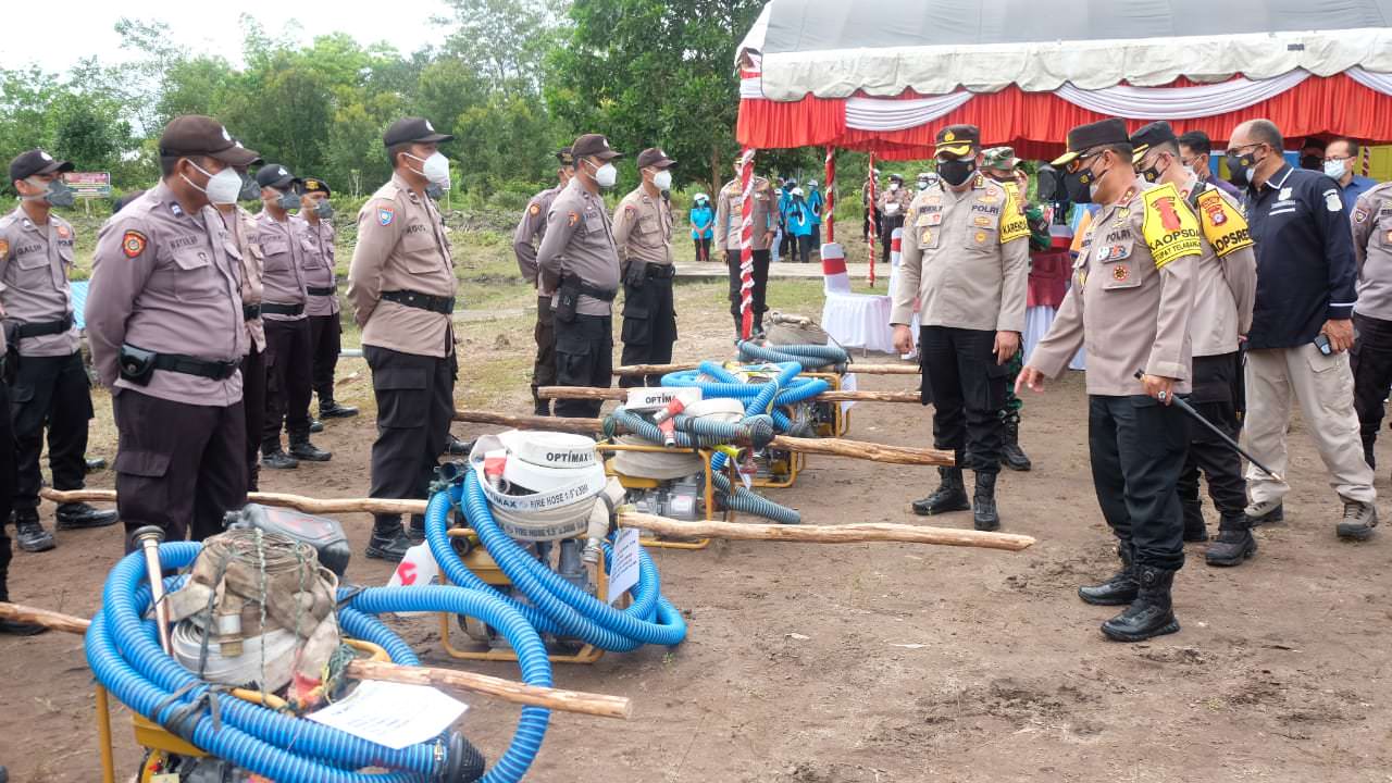 CEK PERALATAN: Kapolda Kalteng Ijen Pol Dedi Prasetyo mengecek peralatan yang dipegang oleh anggota yang hendak memadamkan api. (HUMAS UNTUK KALTENG POS)