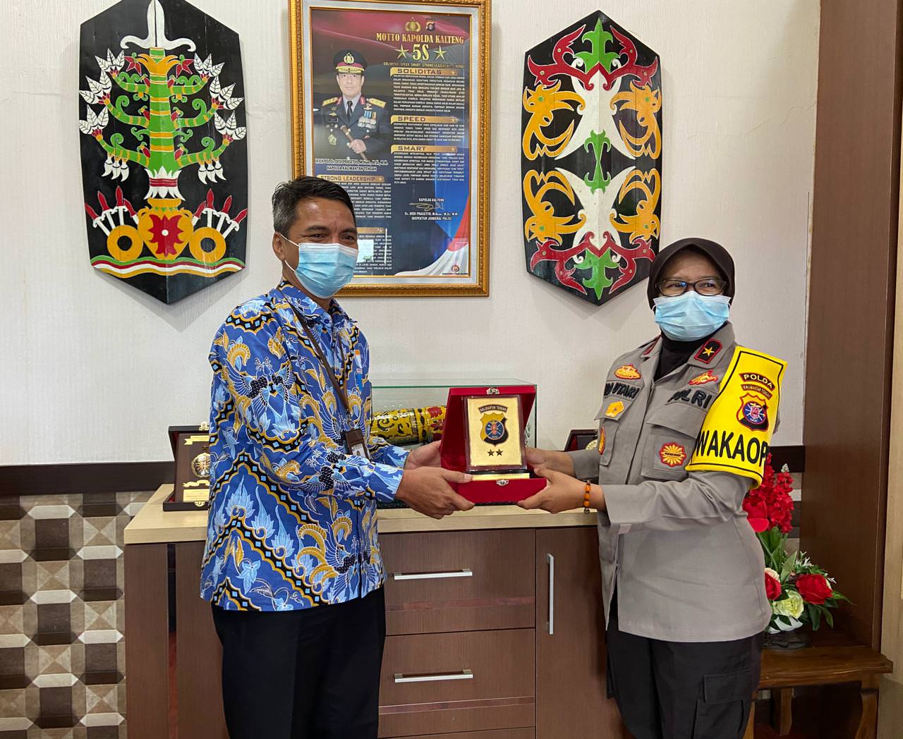 SINERGI: Wakapolda Kalteng Brigjen Ida Oetari menyerahkan cendera mata kepada Kepala Perwakilan Ombudsman RI Kalteng Biroum Bernardianto, Selasa (25/5). (OMBUDSMAN UNTUK KALTENG POS)