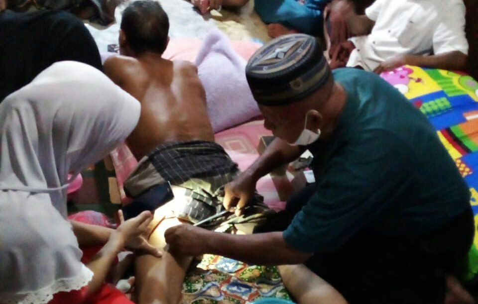 DISAMBAR BUAYA: H.Salman (60) saat dijahit  lukanya oleh orang kesehatan usai diterkam buaya pada Senin (31/5) malam.