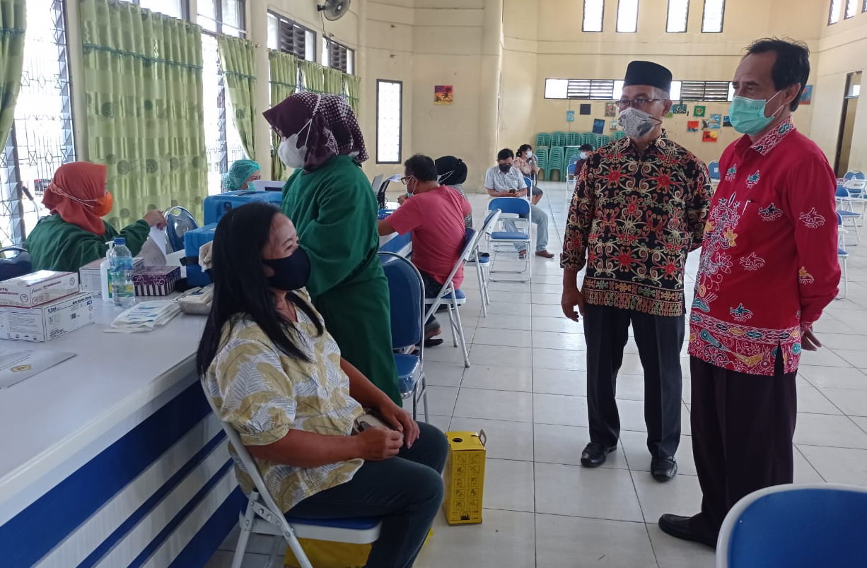 Kepala Sekolah SMAN 5 PAlangka Raya ,Muhammad Ramli (baju batik merah) melihat pelaksanaan vaksinasi Covid-19 di aula SMAN-5, Kamis (10/6/2021).