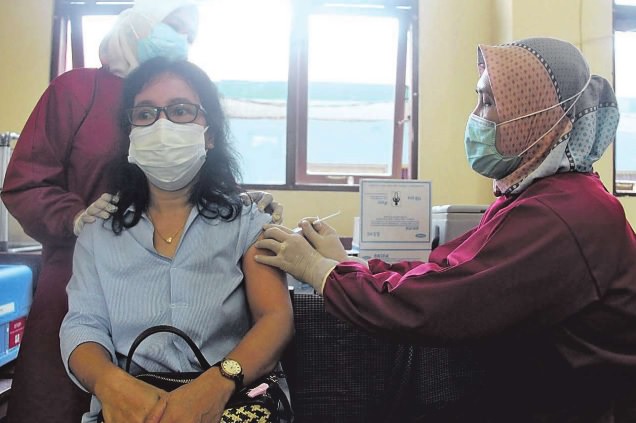 VAKSINASI: Salah seorang wali murid SMPN 1 Palangka Raya saat mengikuti kegiatan vaksinasi di Ruang Kelas SMPN 1 Palangka Raya, Sabtu (5/6). (PATHUR/KALTENG POS)