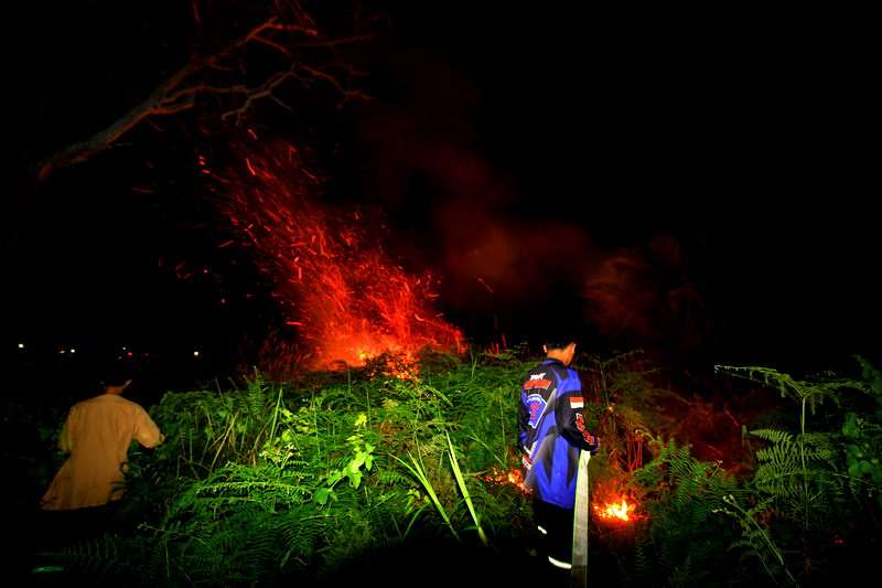 PEMADAMAN: Petugas pemadam kebakaran bersama BPK Swakarsa Padamkan lahan terbakar di Jalan Lintas Mahir Mahar, Senin petang (12/7). FOTO: DENAR/KALTENG POS