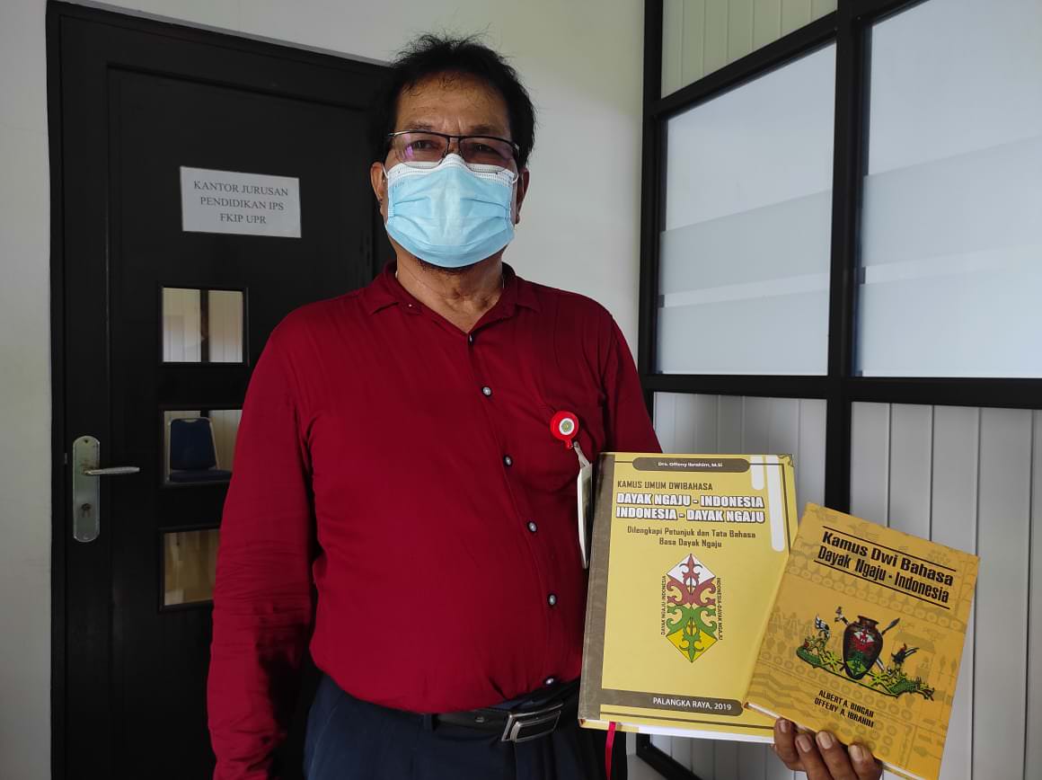 PERLIHATKAN KAMUS: Offeny Ibrahim memperlihatkan dua kamus bahasa Dayak Ngaju yang disusunnya, saat ditemui di kantor Jurusan IPS FKIP UPR, beberapa waktu lalu. FOTO: ANISA/KALTENG POS