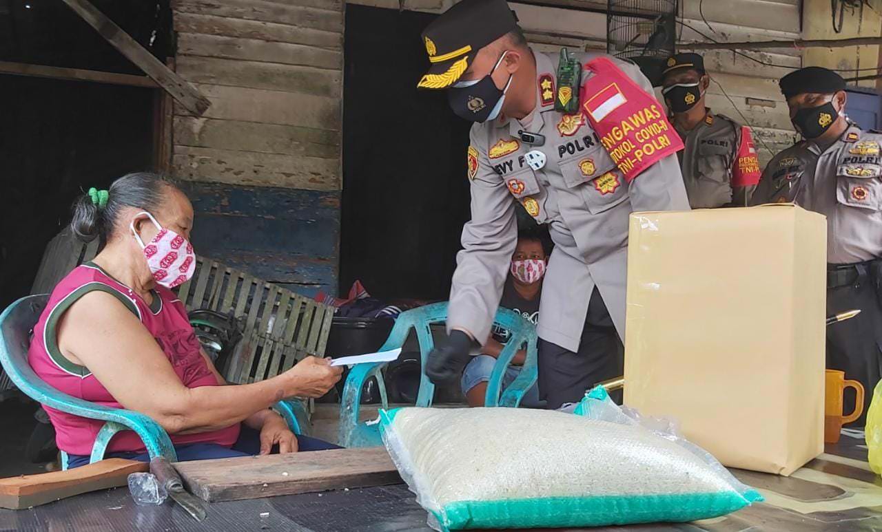 BLUSUKAN: Kapolres Kobar AKBP Devi Firmansyah ketika menyerahkan bansos kepada warga terdampak PPKM Mikro, Rabu (28/7). (SONY/KALTENG POS)