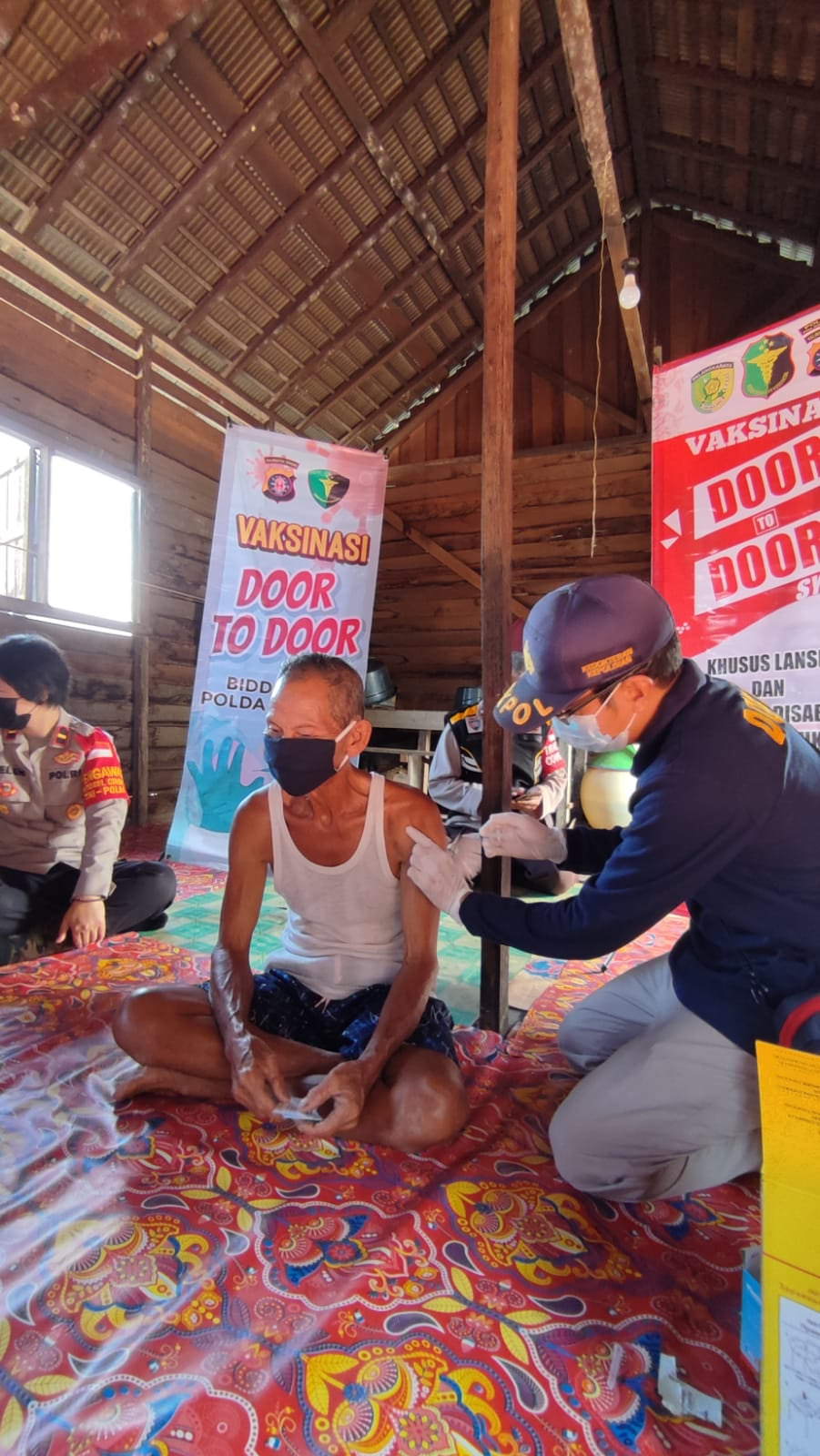 VAKSINASI: Vaksinator dari Biddokkes Polda Kalteng mendatangi langsung rumah para lansia di daerah pinggiran atau di perkampungan. (FOTO: HUMAS POLDA)