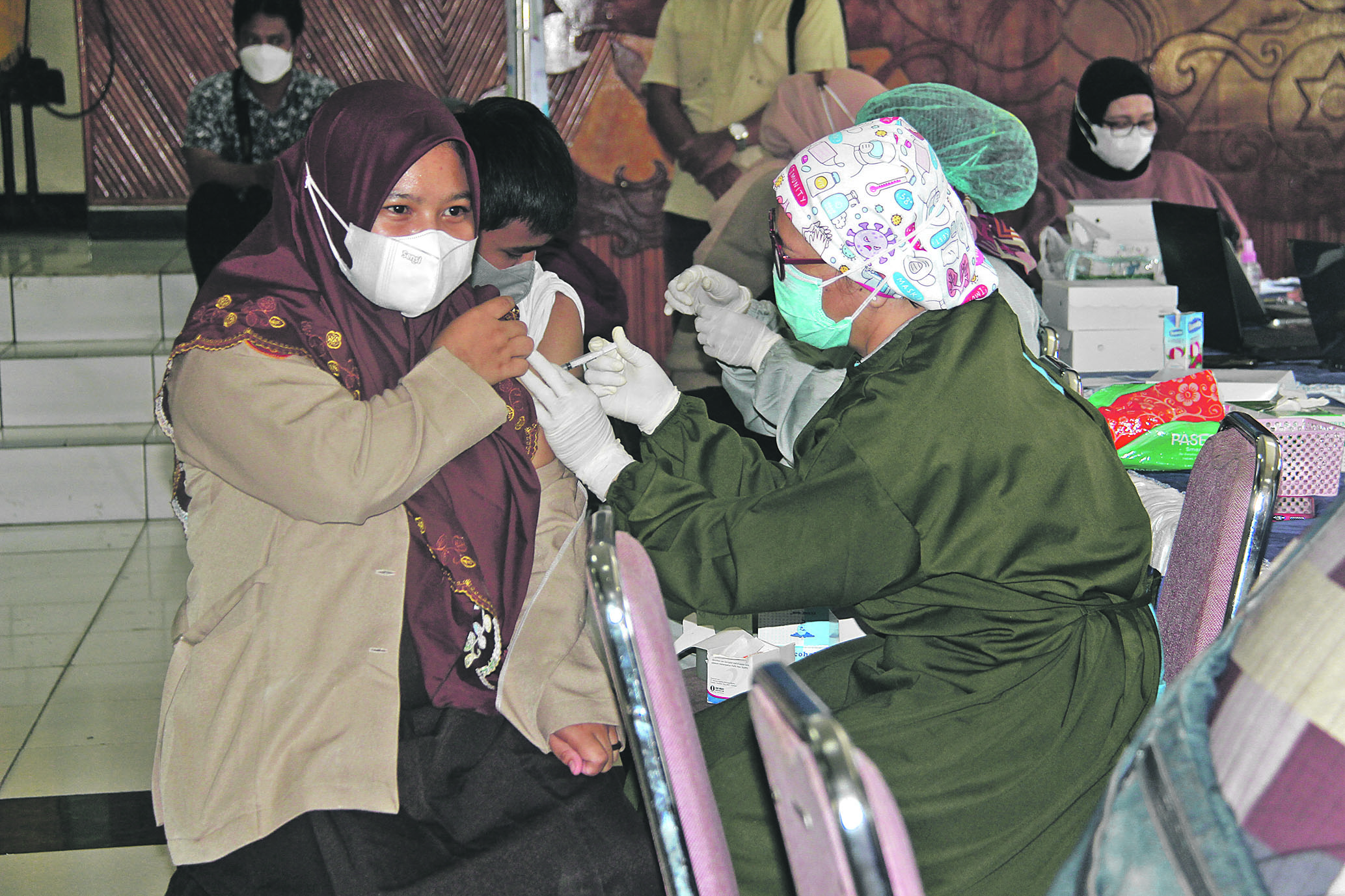 PATHUR / KALTENG POS ANTUSIAS: Santriwati saat divaksinasi Covid-19 dosis satu di Gedung Pertemuan Umum Palampang Tarung, Sabtu (25/9).
