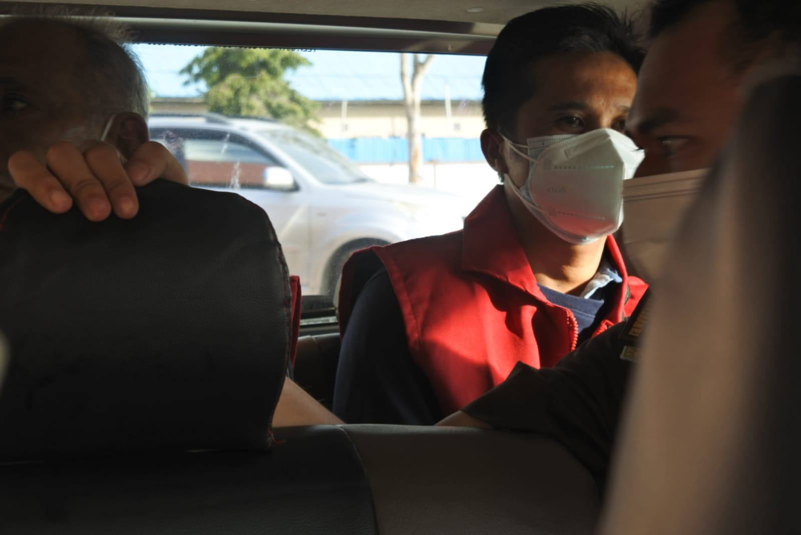 DIGIRING:  YS dan DM mengenakan rompi oranye digiring petugas untuk ditahan di Rutan Tamiang Layang.