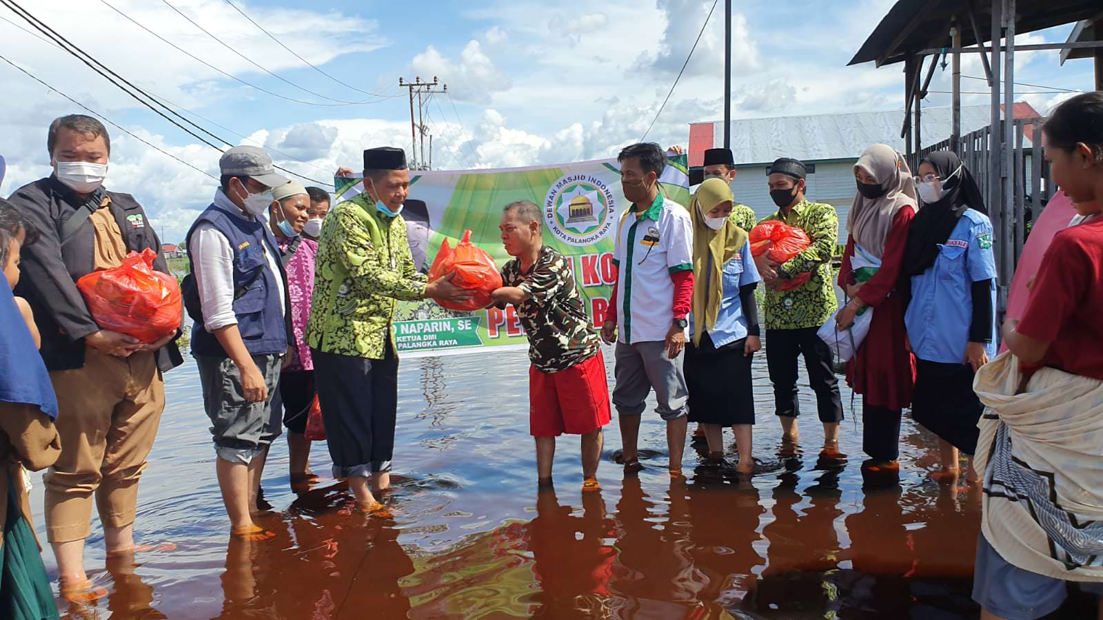 SERAHKAN BANTUAN: Ketua Harian DMI Kota H. Rus’ansyah menyerahkan paket sembako secara simbolis kepada warga terdampak banjir kompleks Mendawai Palangka Raya, Selasa (14/9).