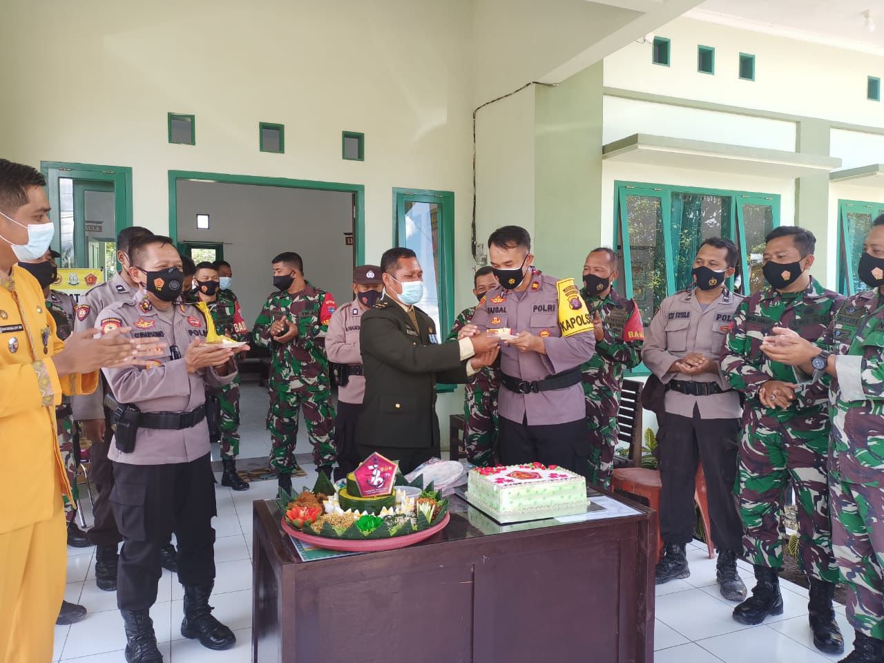 KEJUTAN: Kapolsek Pangkalan Banteng Iptu Faisal Firman Gani ketika menerima potongan kue dari Danramil Pangkalan Banteng Pelda Supriyanto pada HUT ke-76 TNI, Selasa (5/10). (POLSEK PANGKALAN BANTENG UNTUK KALTENG POS)
