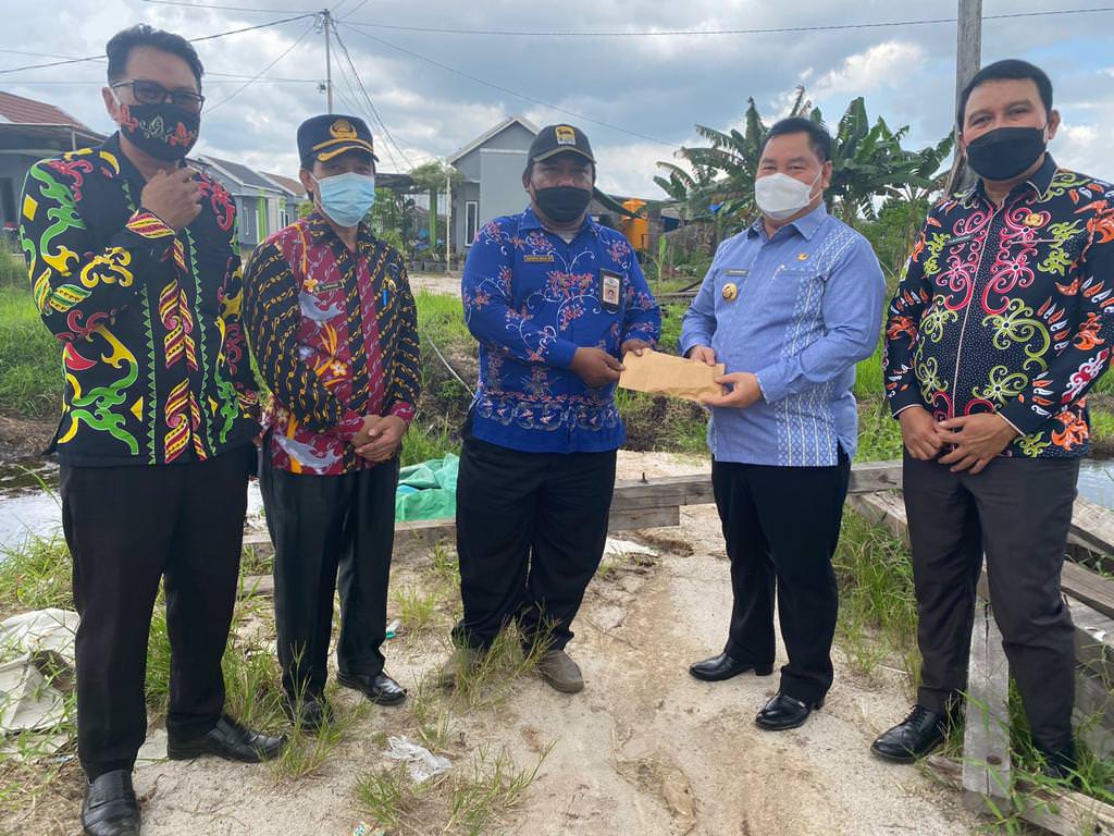 PEDULI: Bupati Kotim, H Halikinnor menyerahkan bantuan pembangunan jembatan, Kamis (7/10).