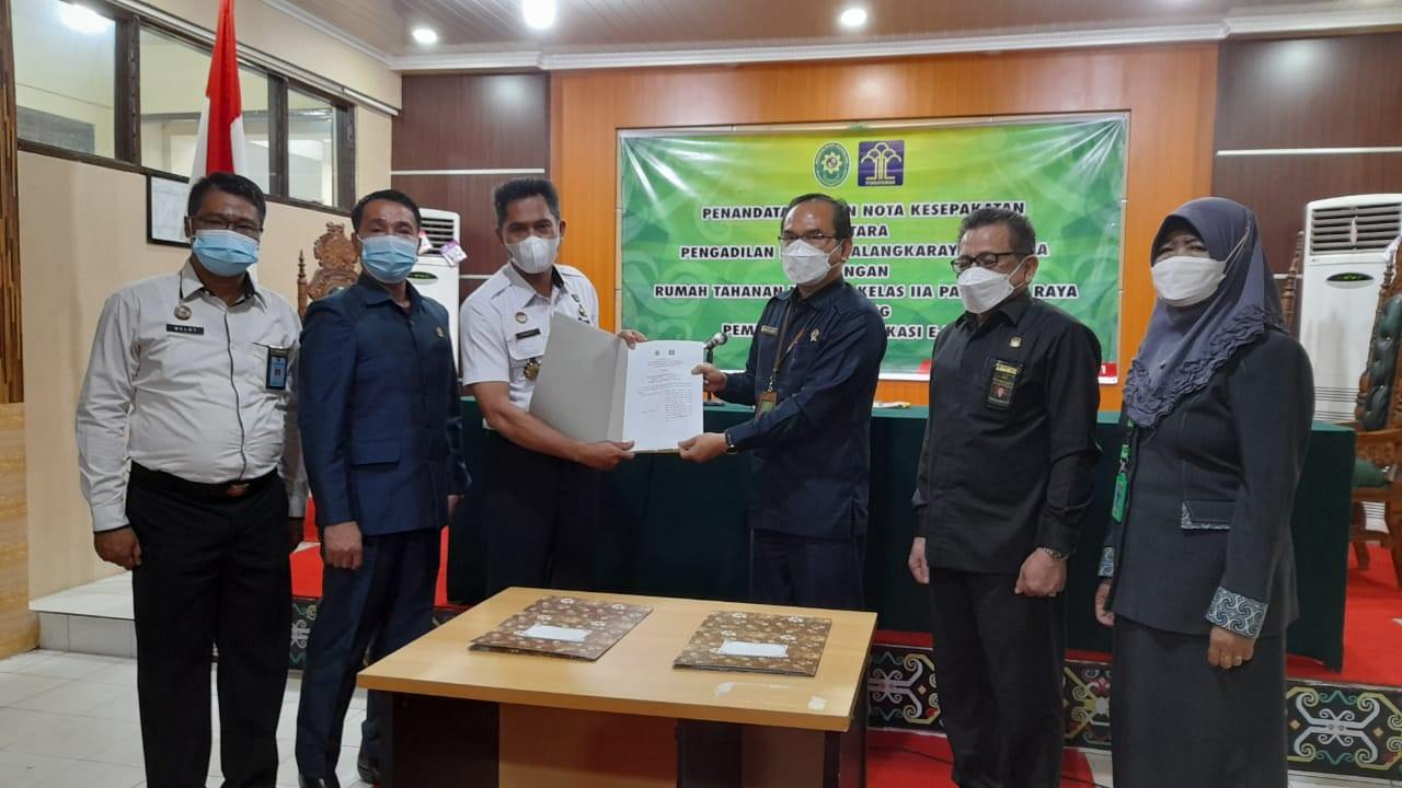 SEPAKAT: Ketua PN Palangka Raya Paskatu Hardinata (baju biru) dan Kepala Rutan Klas IIA Palangka Raya, Suwarto, melakukan penandatangan kesepakatan penerapan aplikasi e-Besuk.