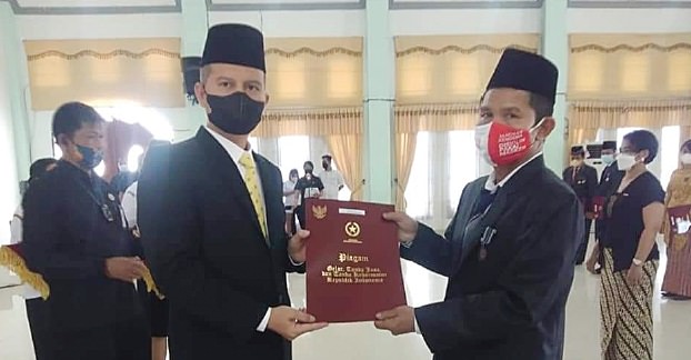 PENGHARGAAN: Bupati Gunung Mas Jaya Samaya Monong (kiri) memberikan tanda kehormatan satyalancana karya satya X, XX dan XXX tahun 2021 kepada PNS di Kabupaten Gunung Mas, beberapa waktu lalu. (KOMINFOSANTIK UNTUK KALTENG POS)