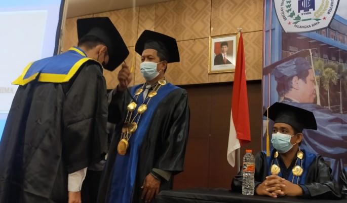 WISUDA : Ketua STMIK Palangka Raya Suparno MKom memindah tali toga wisudawan berprestasi saat pelaksanaan wisuda di salah satu hotel di Kota Palangka Raya,Senin(29/11/2021). FOTO  WUDI ASHADI / KALTENG POS