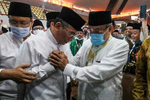 SALING RANGKUL: Ketua Umum PBNU 2021-2026 Yahya Cholil Staquf (tengah) bersalaman dengan Ketua Umum PBNU 2015-2021 Said Aqil Siradj usai proses pemilihan Ketum pada Muktamar NU ke-34 di Gedung Serbaguna Universitas Lampung, Bandar Lampung, Jumat (24/12).