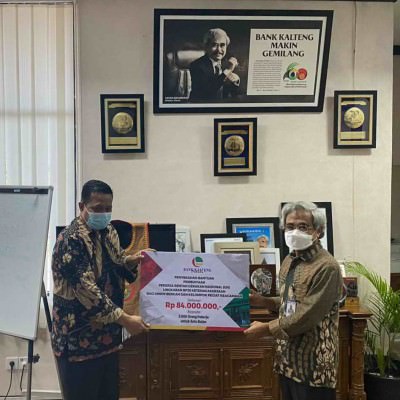 SERAH TERIMA : Direktur Utama Bank Kalteng Yayah Diasmono (kanan) menyerahkan bantuan melalui BPJAMSOSTEK Palangka Raya di Kantor Pusat PT Bank Kalteng, Kamis (30/12). BANK KALTENG UNTUK KALTENG POS
