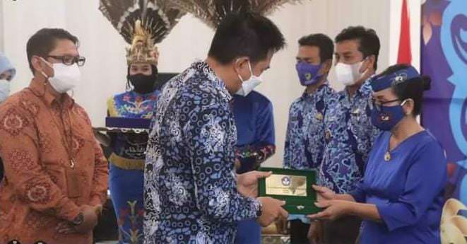PENGHARGAAN : Bupati Barito Utara H Nadalsyah menyerahkan penghargaan anugerah kebudayaan berupa pin dan piagam serta uang pembinaan kepada salah satu pelaku seni pelantun lagu Dongkoi, Irma Iriani yang merupakan guru agama Kristen SMAN 1 Gunung Timang, K