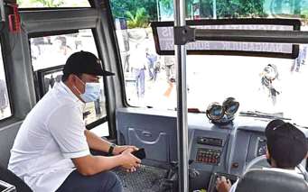 CEK ARMADA : Bupati Lamandau H Hendra Lesmana (kiri) mengecek bus Damri saat meresmikan angkutan perintis Damri di Terminal Garantung, belum lama ini.