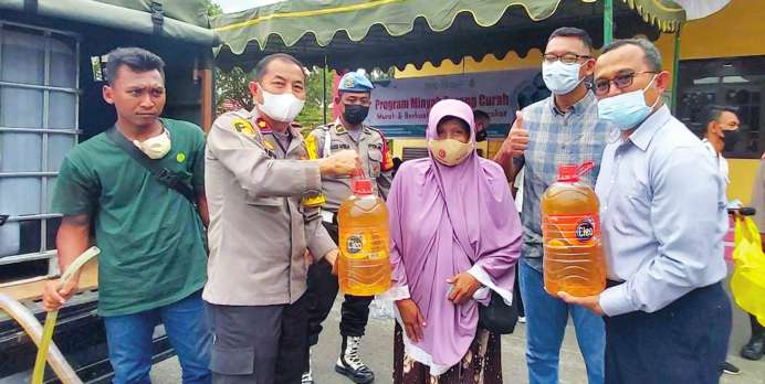BAZAR MIGOR : Corporate Head Division HRDA CBI Group, Hendri Ratoe Bachtiar (kanan) bersama Kapolsek Arsel Kompol Saiful Anwar menyerahkan minyak goreng murah di Mapolsek, Selasa (22/2).