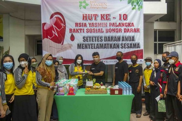 SYUKURAN SEDERHANA: Pemilik RSIA Yasmin dr. Sigit Nurfianto, Sp.OG (K) memberikan nasi tumpeng kepada Direktur RSIA Yasmin Maria Dewi Purwanti disaksikan seluruh karyawan dan peserta donor darah, kemarin (28/2). AGUS PRAMONO/KALTENG POS