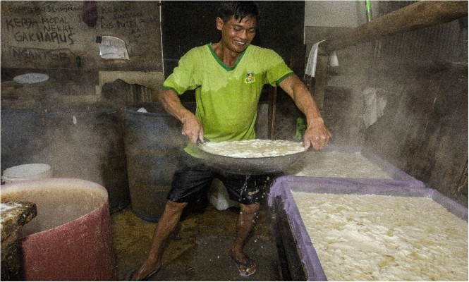 KEDELAI MAHAL: Siswanto, produsen tahu di Jalan Lele memindahkan sari kedelai ke papan pencetak tahu, Selasa (1/3). 