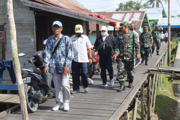 MENINJAU : Kasdim 1016 Palangka Raya Letkol Inf Abdul Salim bersama petugas dari Disperkimtan Kota Palangka Raya meninjau lokasi TMMD di Kelurahan Petuk Katimpun, Kamis (28/7).