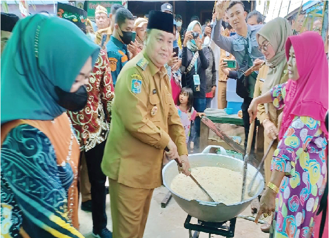 BUBUR ASYURA: Bupati Kotim H Halikinnor turut serta mengaduk bubur asyura pada festival yang dilaksanakan oleh masyarakat Kelurahan Baamang Hulu, Selasa (9/8).