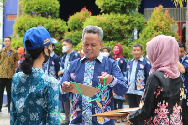 SIMBOLIS: Ketua STMIK Palangkaraya Suparno M. Kom memasangkan atribut kepada salah satu peserta OMB dan matrikulasi tahun 2022, setelah pelaksanaan upacara bendera untuk peringati HUT ke-77 RI di halaman STMIK Palangkaraya, Rabu (17/8).