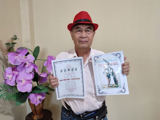 LESTARIKAN BAHASA DAYAK: Piet Johanes Dadie memperlihatkan dua buku karyanya.