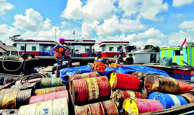 BARANG BUKTI: Tim Pangkalan TNI AL (Lanal) Banjarmasin ketika memeriksa drum berisi BBM jenis solar yang menjadi barang bukti kasus, Jumat (12/8).
