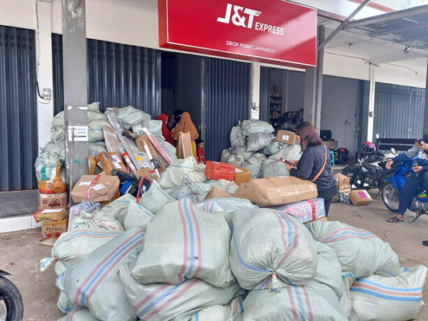 MENGGUNUNG: Ratusan paket milik konsumen menumpuk di depan kantor J&T Express Lamandau, Selasa (20/9). FOTO: RUSLAN/KALTENG POS