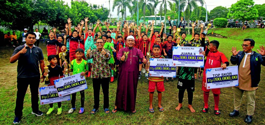 BERSAMA JUARA: Komisaris Utama PT Jamkrida Dr H Rahmat N Hamka bersama Direktur PT Kalteng Pos Press Dr HM Wahyudie F Dirun dan para juara turnamen sepak bola di lapangan mini Kalteng Pos, Jumat (9/9).