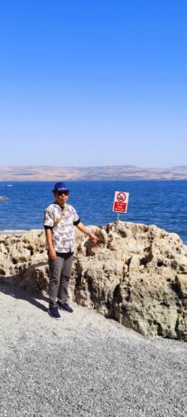 MENIKMATI: Salah satu peserta perjalanan rohani bersama PT Flo Go menikmati pemandangan di sebelah Church of the Primacy of Peter yang terletak di Tabgha, tepi pantai barat Danau Galilea, Selasa (27/09/2022).