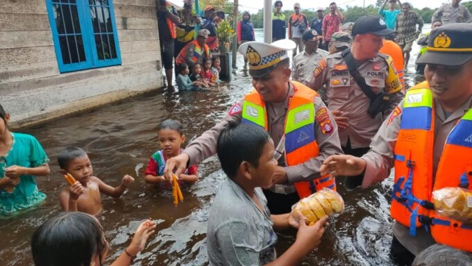 PEDULI: Kasatlantas Polres Kotim, AKP Salahiddin (tengah) menghibur anak-anak dengan memberikan bingkisan. FOTO: RUSLI/KALTENG POS