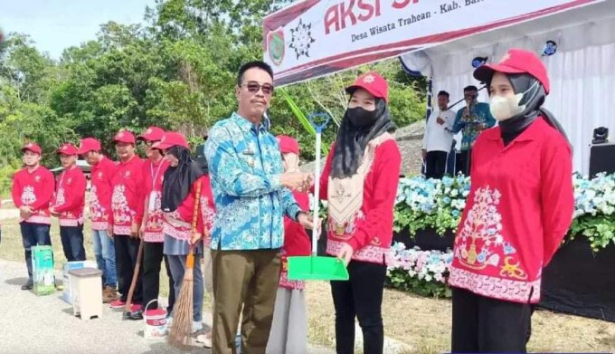 Wakil Bupati Barito Utara Sugianto Panala Putra menyerahkan peralatan kebersihan pada aksi sapta pesona di Bumi Perkemahan Panglima Batur, Sabtu (26/11/2022). DISKOMINFOSANDI UNTUK KALTENG POS