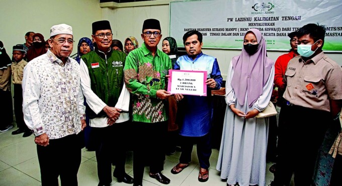 SEMOGA BERMANFAAT: Ketua Tanfi dziyah PWNU Kalteng Dr HM Wahyudie F Dirun SP MM secara simbolis memberikan beasiswa kurang mampu kepada siswa-siswi penerima, Sabtu (26/11). FOTO: ARIEF PRATHAMA/KALTENG POS