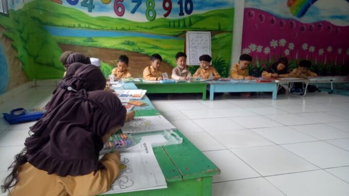 SERU: Anak didik TK Islam Darussalam mewarnai gambar di koran Kalteng Pos. FOTO: HENY/KALTENG POS