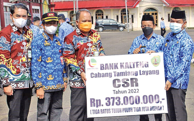 DUKUNGAN: Pemimpin Bank Kalteng Cabang Tamiang Layang, Soleman Hukubun menyerahkan bantuan CSR yang diterima Bupati Ampera AY Mebas didampingi Wabup Habib Said Abdul Saleh dan Sekda Panahan Moetar, dalam rangkaian Apel Gabungan memperingati Hari Bela Nega
