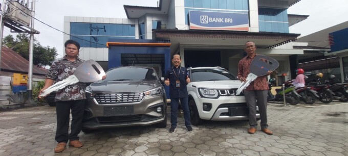 SIMBOLIS: Pemimpin BRI Cabang Pangkalan Bun Romanata (tengah) saat menyerahkan replika kunci mobil hadiah utama undian Simpedes kepada dua pemenang, di halaman Kantor BRI, Senin (26/1).