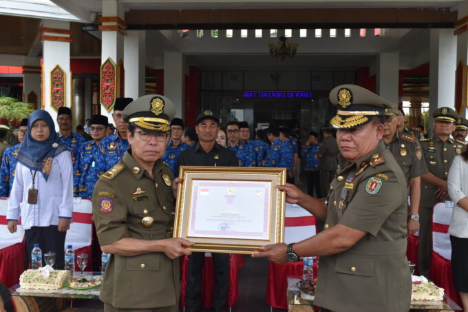 Bupati Katingan Sakariyas menerima penyerahan piagam Karya Bhakti Satpol PP yang didapat dari Menteri Dalam Negeri RI beberapa waktu lalu diserahkan Kepala Satpol PP dan Damkar Kabupaten Katingan Pimanto pada saat apel gabungan, Senin (20/3/2023). (HUMAS