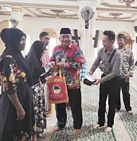 BERBAGI : Pimpinan Bank Kalteng Cabang Kasongan Empas S Umar ketika menyerahkan paket sembako dan santunan kepada warga Desa Hampalit, Selasa (18/4).